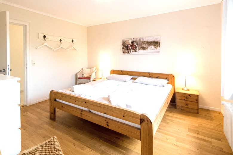 Erstes Schlafzimmer mit Doppelbett, Kommode und Kleiderschrank