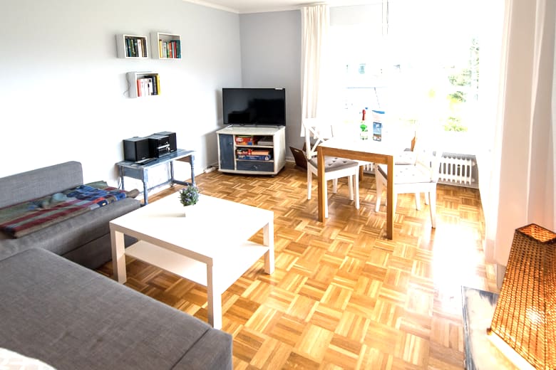 Wohn- und Esszimmer mit großen Panoramafenstern zum Garten